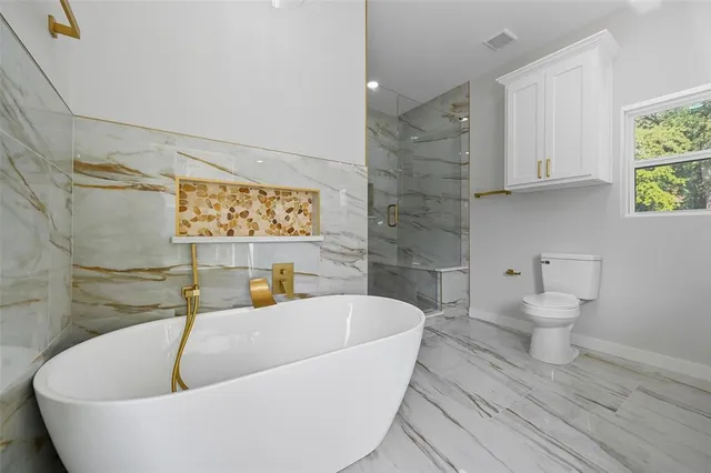 a white bath tub sitting next to a white toilet