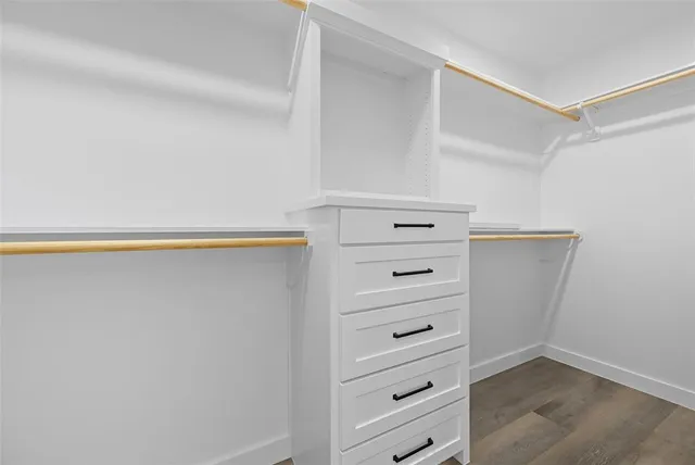 a view of walk in closet with empty racks