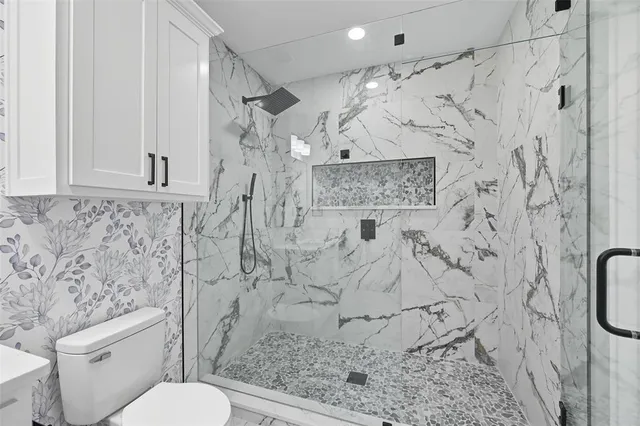 a bathroom with a toilet and shower