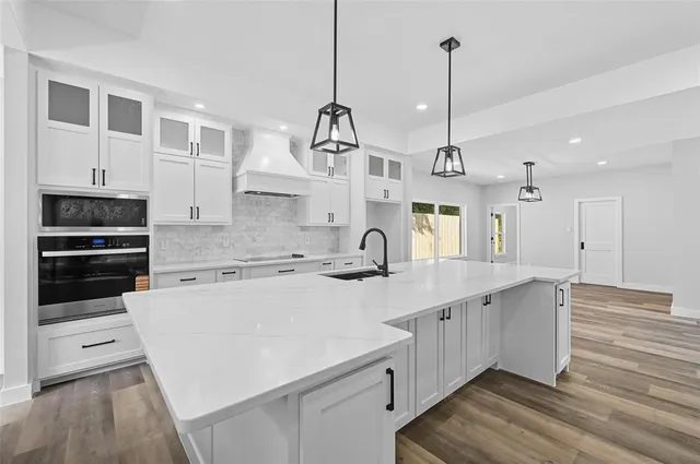 a kitchen with stainless steel appliances granite countertop a sink a stove and a refrigerator