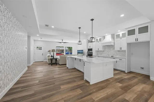 a kitchen with stainless steel appliances kitchen island granite countertop a stove a sink and a refrigerator