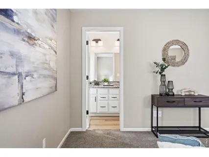 a view of a hallway with front door wooden floor and cabinet