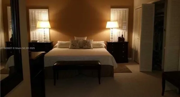 a bedroom with a bed and a lamp next to a window