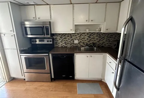 a kitchen with granite countertop a stove and a microwave