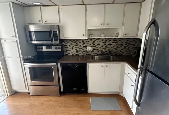 a kitchen with granite countertop a stove and a microwave