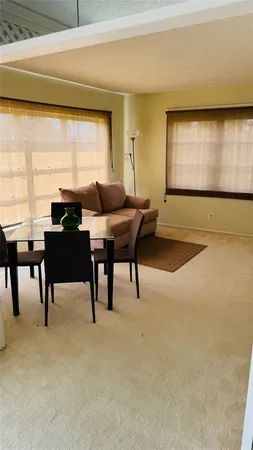 a living room with furniture a large window and a wooden floor