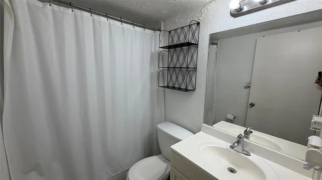 a view of a house with large trees and plants