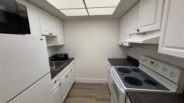 a kitchen with granite countertop a stove and a sink