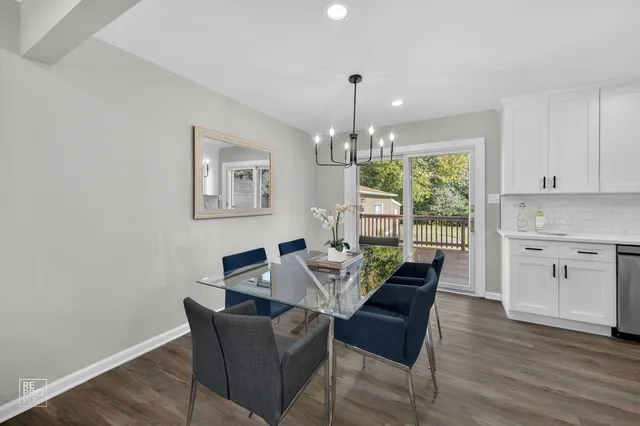 a dining room with furniture a chandelier and wooden floor