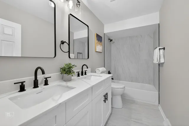 a bathroom with a double vanity sink mirror and toilet