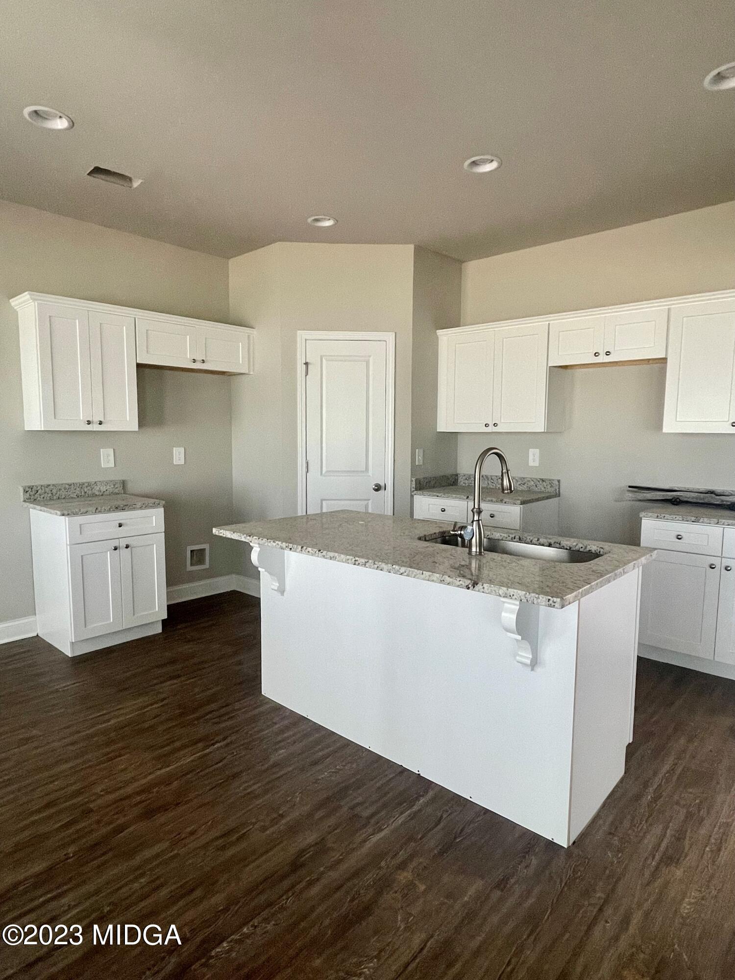 706 Sutton Road Forsyth, GA 31029 - Photo 2 of 3 a large kitchen with stainless steel appliances granite countertop a white cabinets a sink a stove a refrigerator and white cabinets