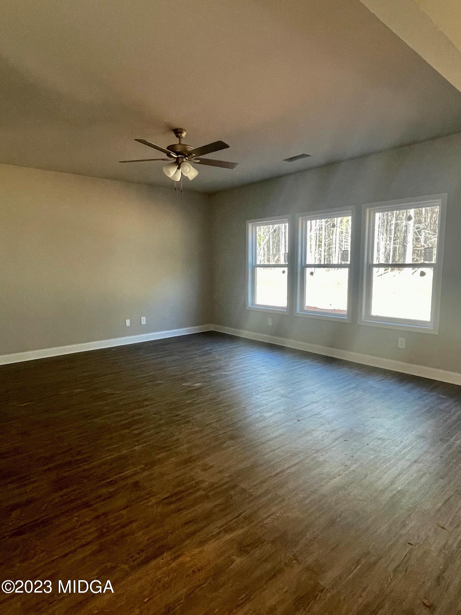 706 Sutton Road Forsyth, GA 31029 - Photo 3 of 3 an empty room with wooden floor and windows