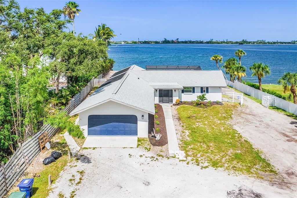 a front view of a house with a garden and lake view