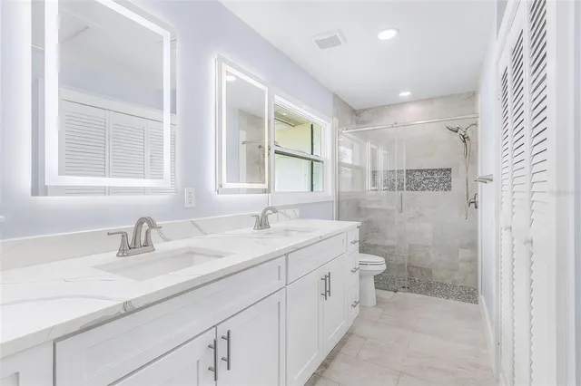 a bathroom with a sink shower and a mirror