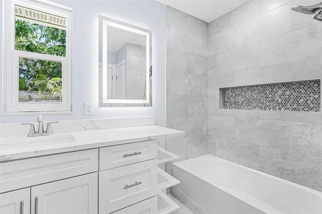 a bathroom with a bathtub sink and window