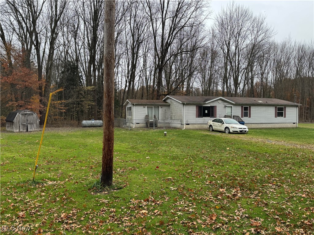 3690 Anderson Anthony Road Leavittsburg, OH 44430 - Photo 2 of 18 View of front of home featuring a front lawn, crawl space, view of scattered trees, and a shed