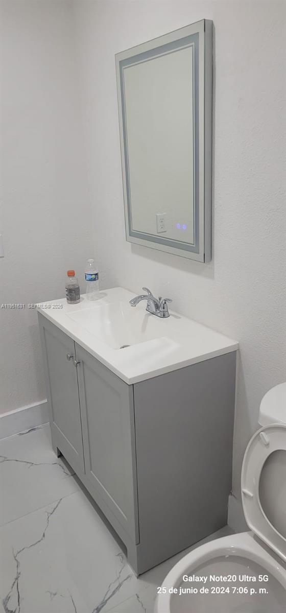 9402 Southwest 77th Avenue, Unit L8 Miami, FL 33156 - Photo 14 of 54 a bathroom with a toilet sink and mirror