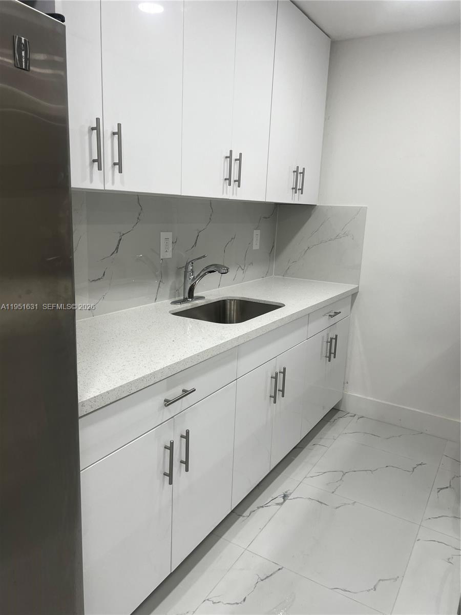9402 Southwest 77th Avenue, Unit L8 Miami, FL 33156 - Photo 23 of 54 a view of cabinets a sink and dishwasher with white cabinets