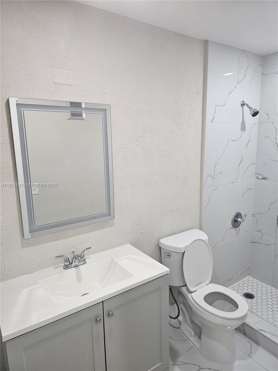 9402 Southwest 77th Avenue, Unit L8 Miami, FL 33156 - Photo 46 of 54 a bathroom with a sink a toilet and mirror
