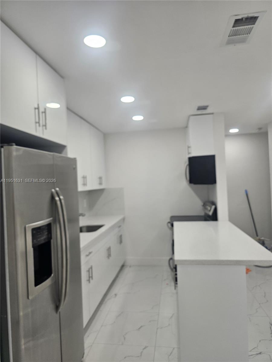 9402 Southwest 77th Avenue, Unit L8 Miami, FL 33156 - Photo 49 of 54 a kitchen with stainless steel appliances a refrigerator sink and microwave