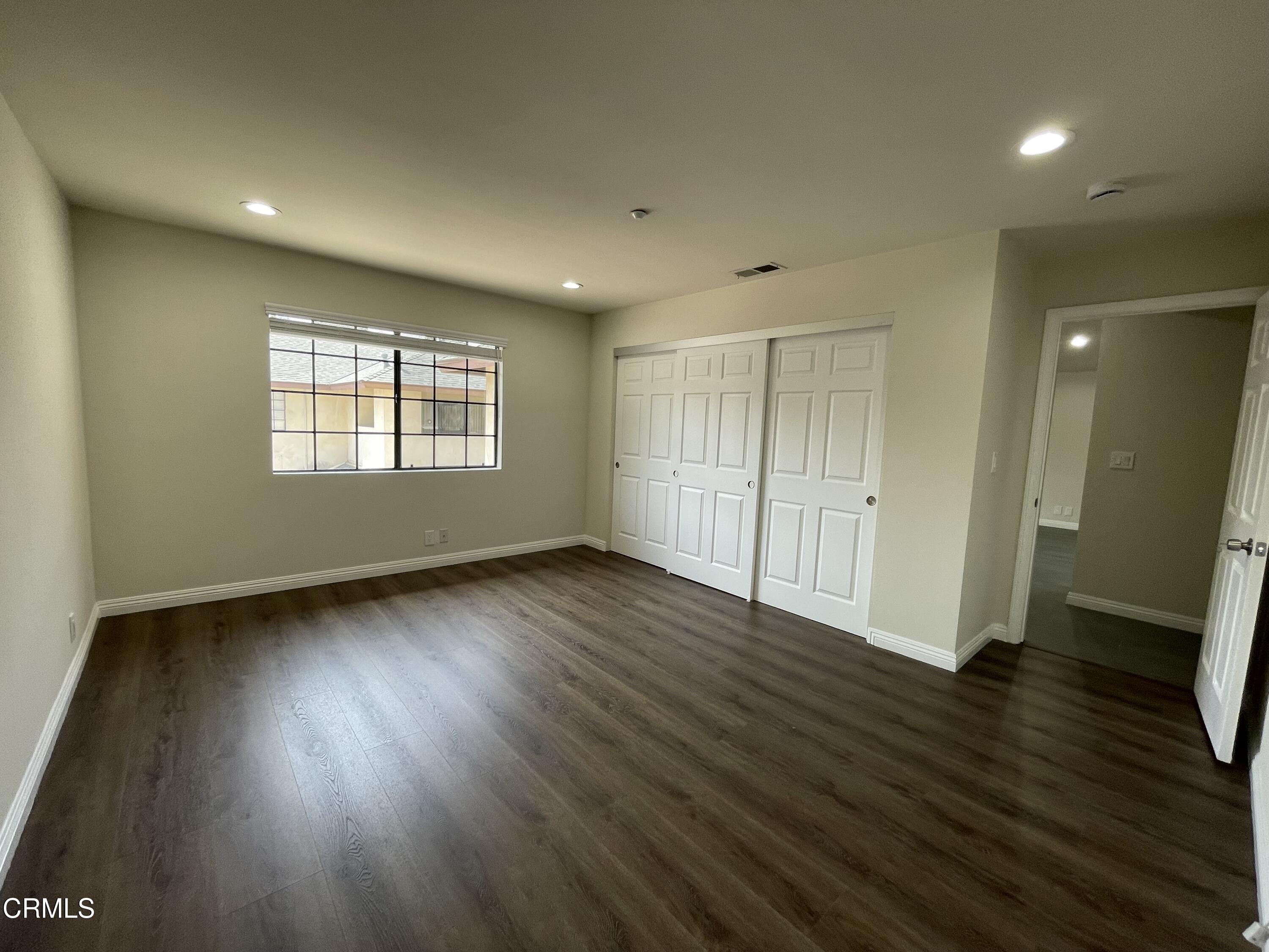 838 Fairview Avenue, Unit N Arcadia, CA 91007 - Photo 9 of 14 an empty room with wooden floor and windows