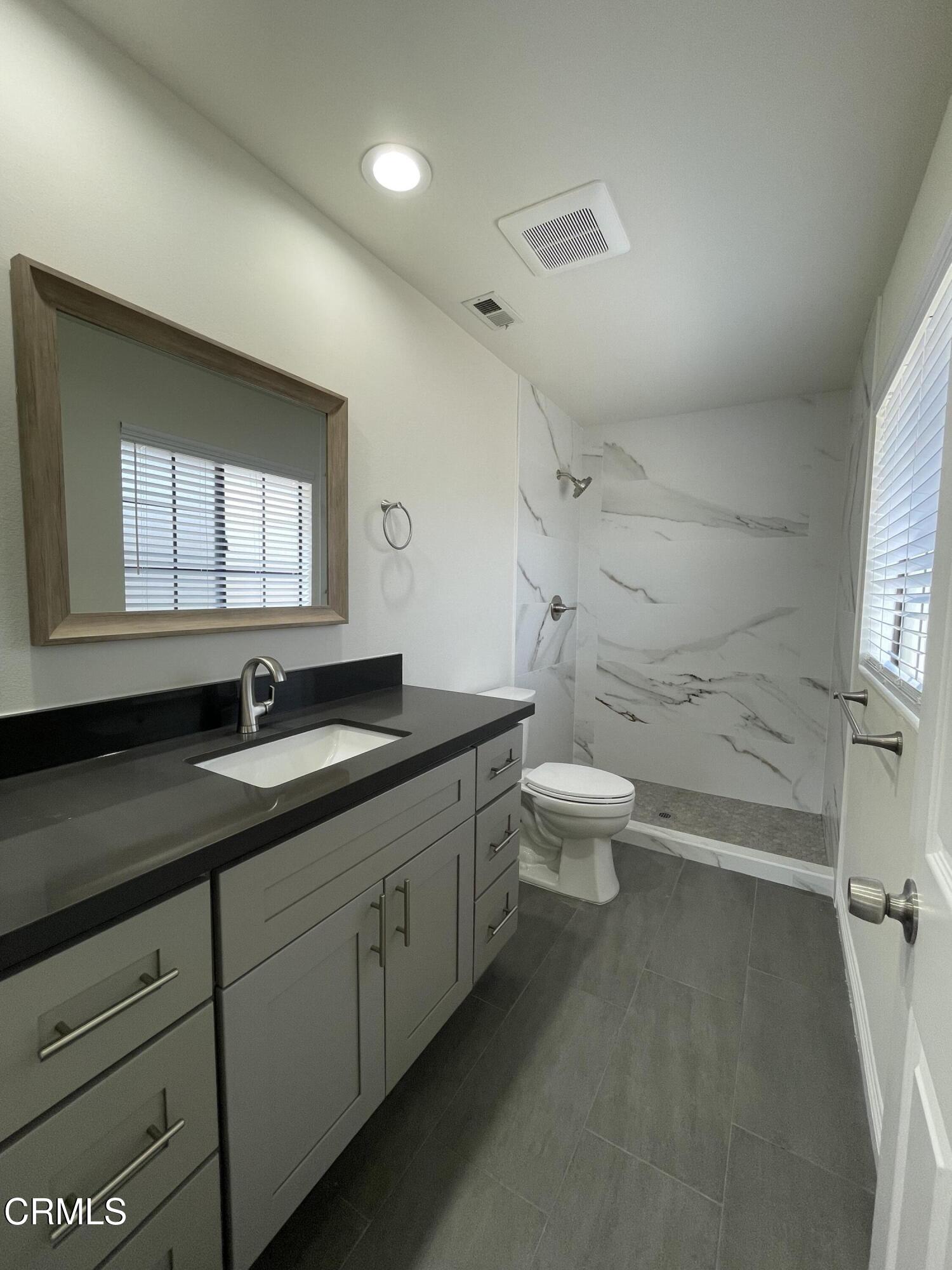 838 Fairview Avenue, Unit N Arcadia, CA 91007 - Photo 10 of 14 a bathroom with a granite countertop sink a toilet a mirror and a window