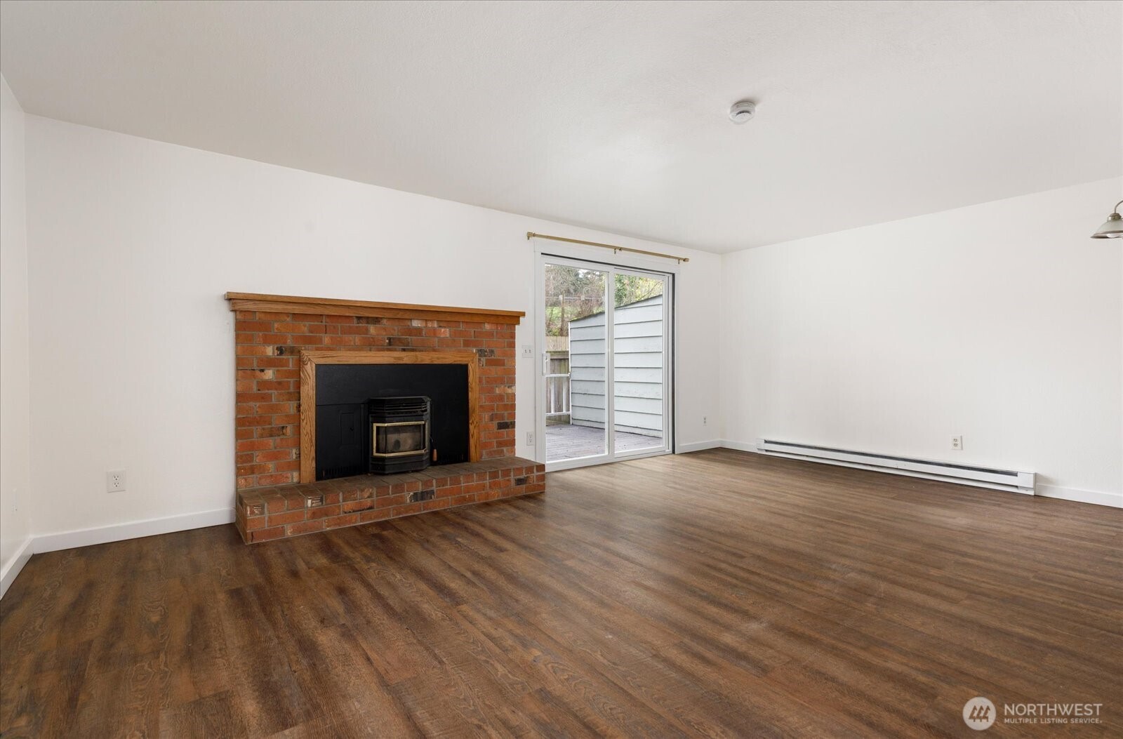 1282 Northwest Lanyard Loop, Unit 2 Oak Harbor, WA 98277 - Photo 4 of 32 an empty room with wooden floor and fireplace