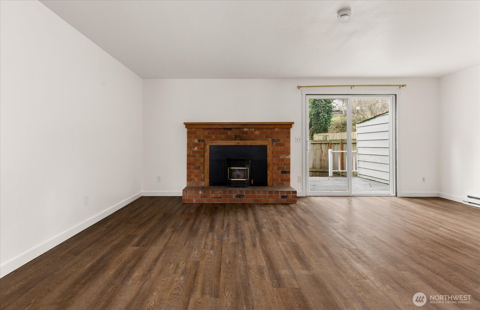 1282 Northwest Lanyard Loop, Unit 2 Oak Harbor, WA 98277 - Photo 5 of 32 an empty room with wooden floor fireplace and windows