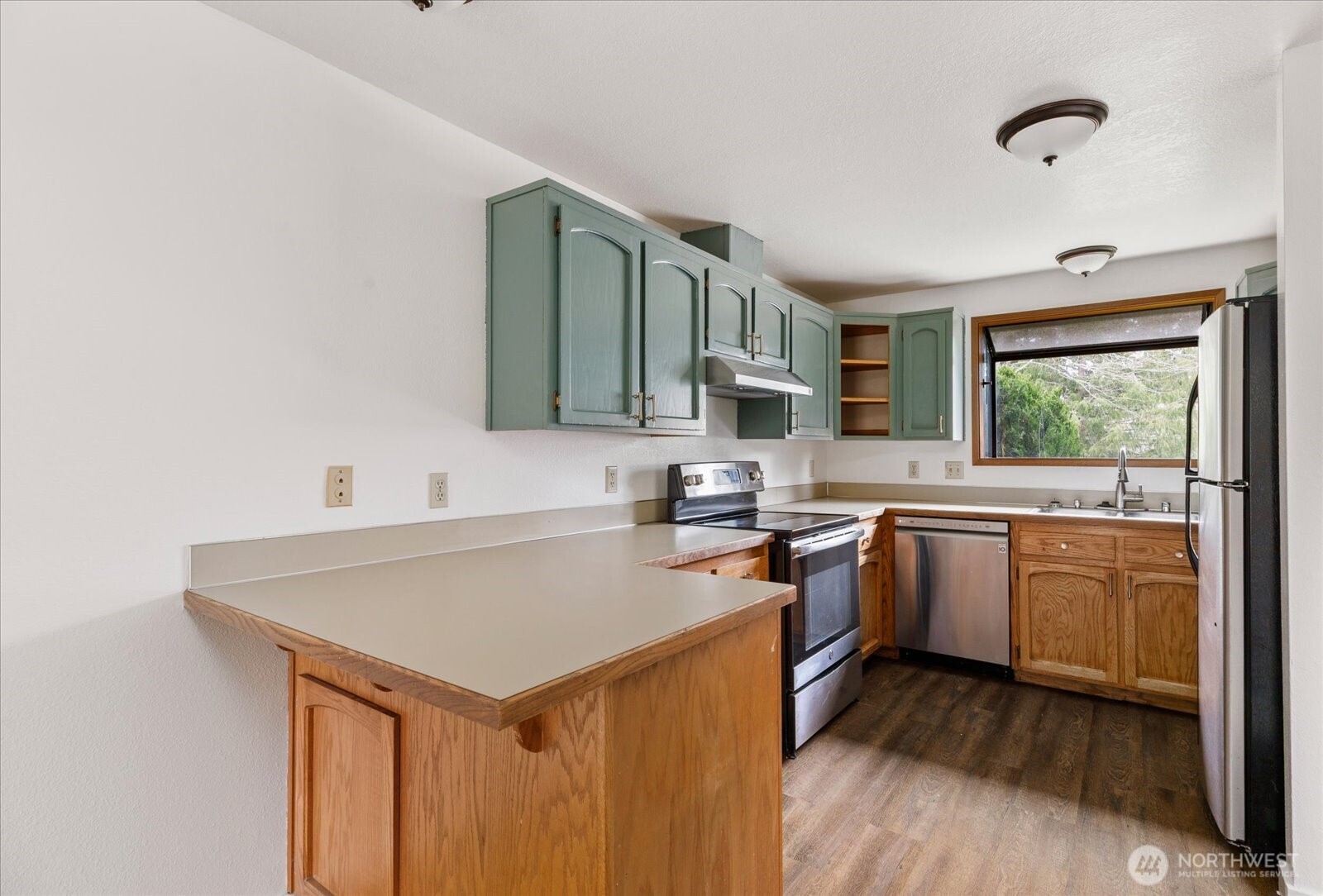 1282 Northwest Lanyard Loop, Unit 2 Oak Harbor, WA 98277 - Photo 8 of 32 a kitchen with a stove a sink and a refrigerator