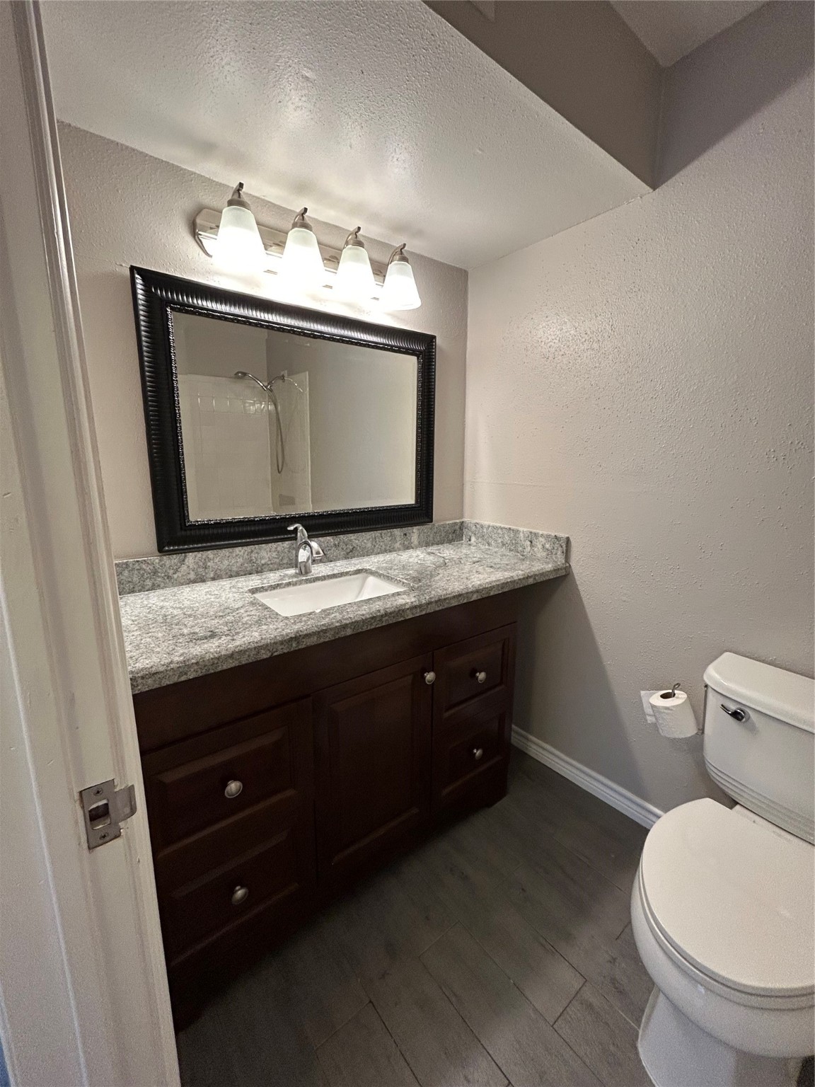 3300 Pebblebrook Drive, Unit 82 Seabrook, TX 77586 - Photo 11 of 13 a bathroom with a granite countertop sink toilet and mirror