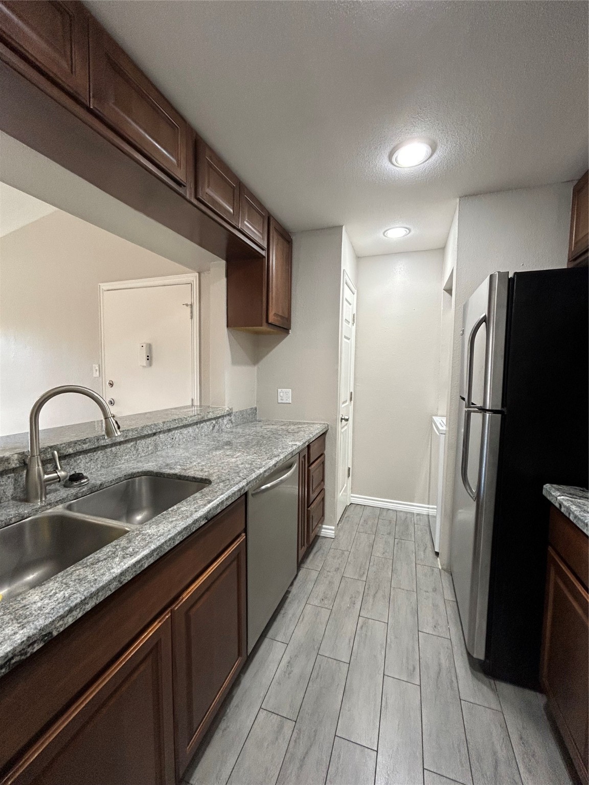 3300 Pebblebrook Drive, Unit 82 Seabrook, TX 77586 - Photo 7 of 13 a kitchen with a sink and refrigerator