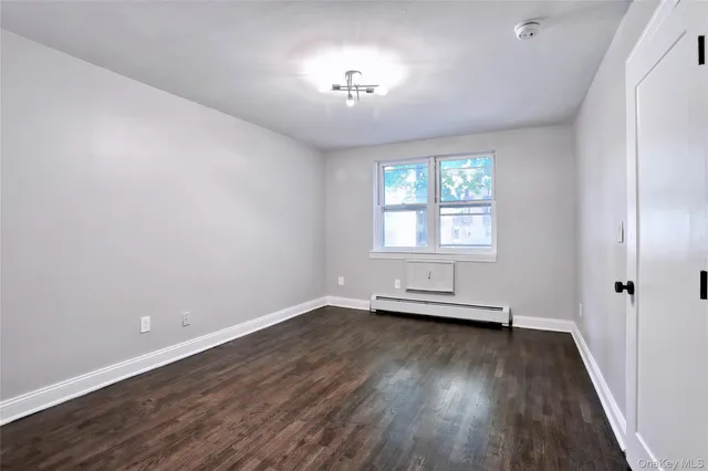 wooden floor in an empty room with a window