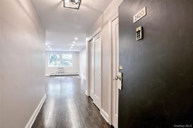 a view of a hallway with wooden floor and a mirror