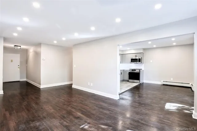 a view of empty room with wooden floor