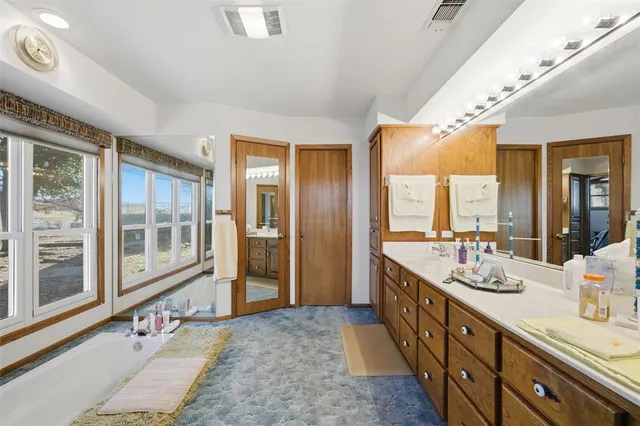 a spacious bathroom with double vanity and a large mirror