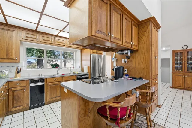 a kitchen with stainless steel appliances granite countertop a sink a stove and refrigerator