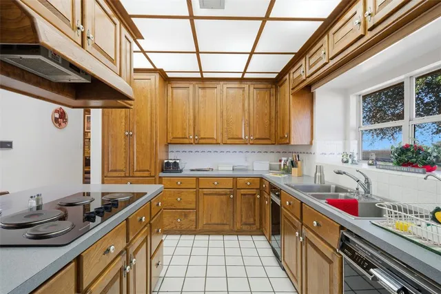 a kitchen with sink a stove and cabinets