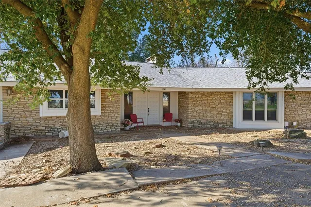 a front view of a house with a tree