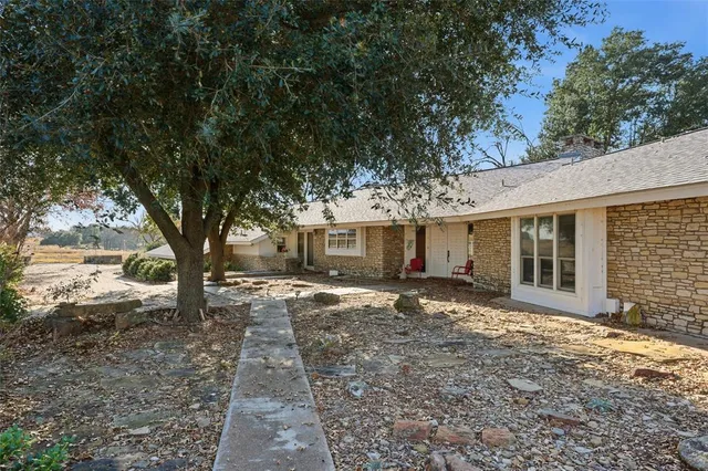 a front view of a house with a garden and trees