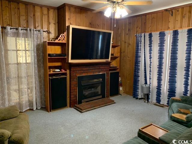 2100 Nesmith Road Nesmith, SC 29580 - Photo 16 of 37 Living room with carpet flooring, wood walls, ceiling fan, and a brick fireplace