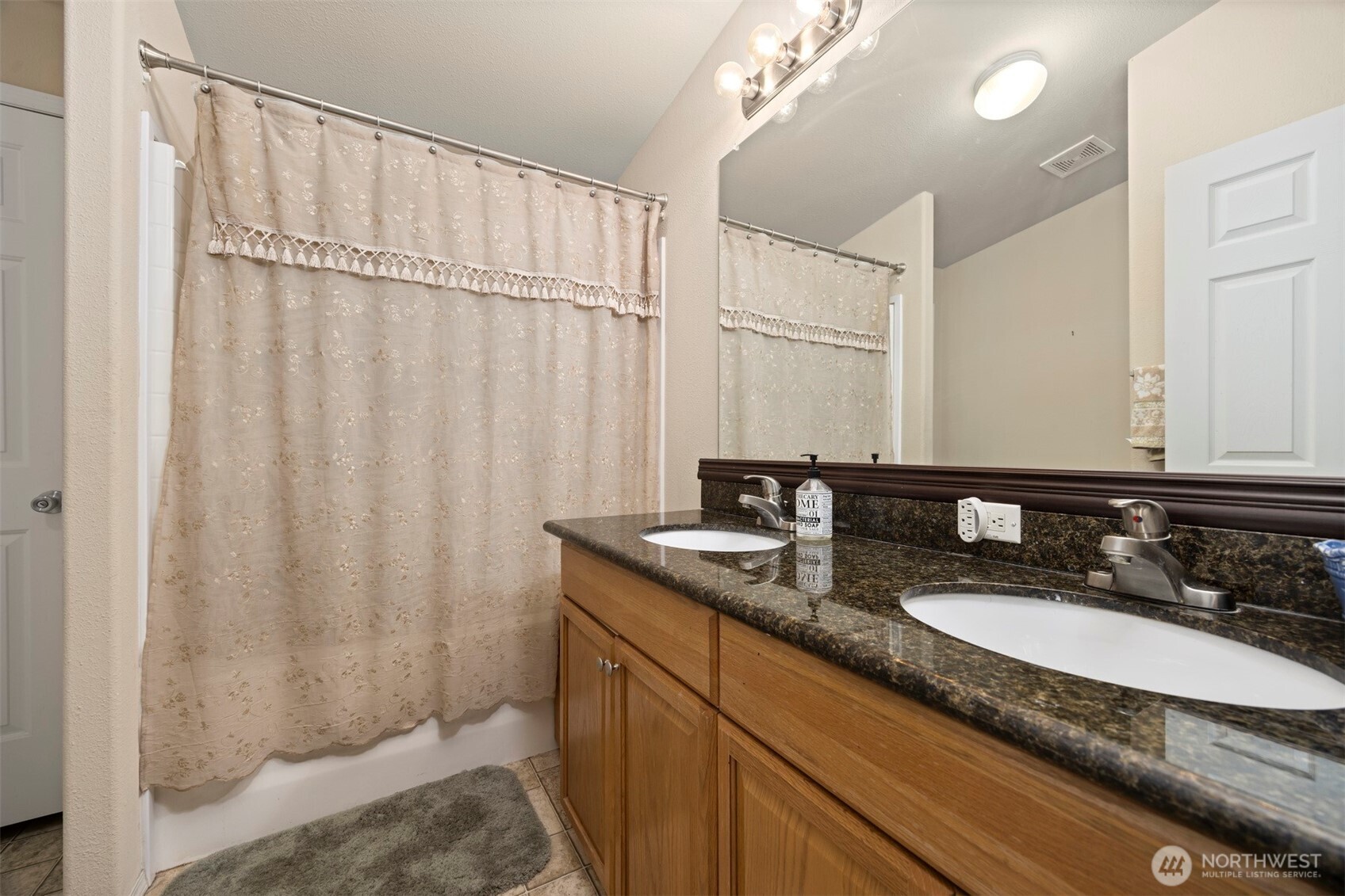11027 Shuksan Rim Drive Deming, WA 98244 - Photo 27 of 39 a bathroom with a granite countertop sink a mirror and a shower curtain