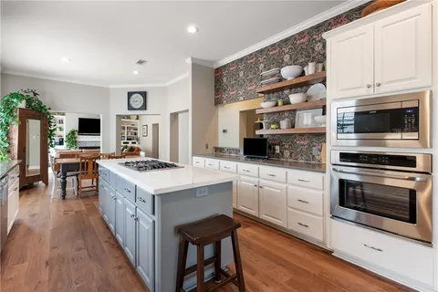 a kitchen with granite countertop a stove top oven microwave and cabinets