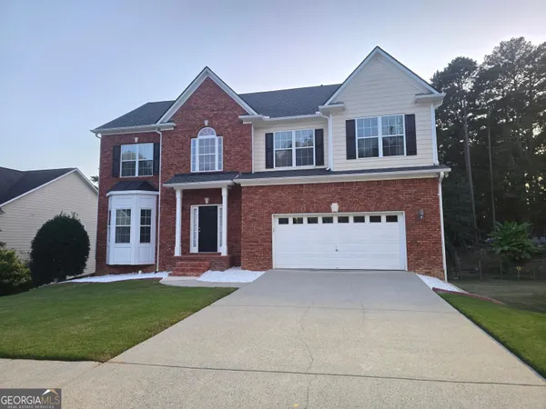 a front view of a house with a garden and yard