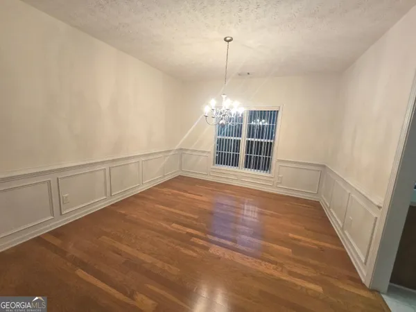 an empty room with wooden floor and window