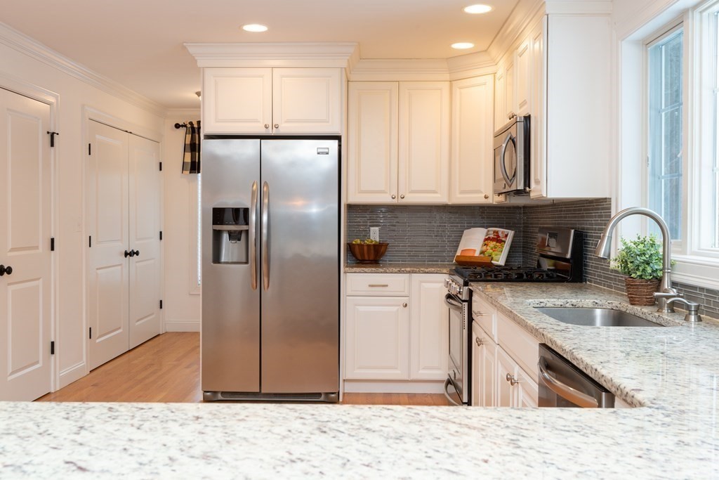 17 Pine Hill Road Lynnfield, MA 01940 - Photo 14 of 42 a kitchen with stainless steel appliances granite countertop a refrigerator a stove and a sink with wooden cabinets