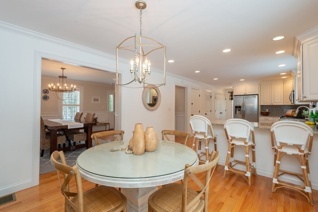 17 Pine Hill Road Lynnfield, MA 01940 - Photo 15 of 42 a dining room with wooden floor a chandelier a glass table and chairs