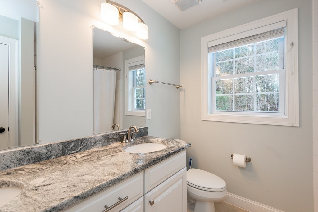 17 Pine Hill Road Lynnfield, MA 01940 - Photo 35 of 42 a bathroom with a granite countertop sink a toilet and a mirror