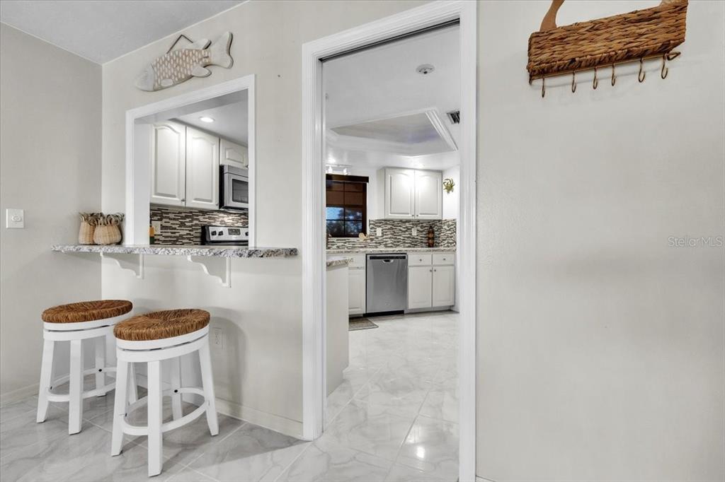 23465 Harbor View Road, Unit 624 Port Charlotte, FL 33980 - Photo 11 of 47 a kitchen with stainless steel appliances kitchen island a refrigerator and a stove top oven