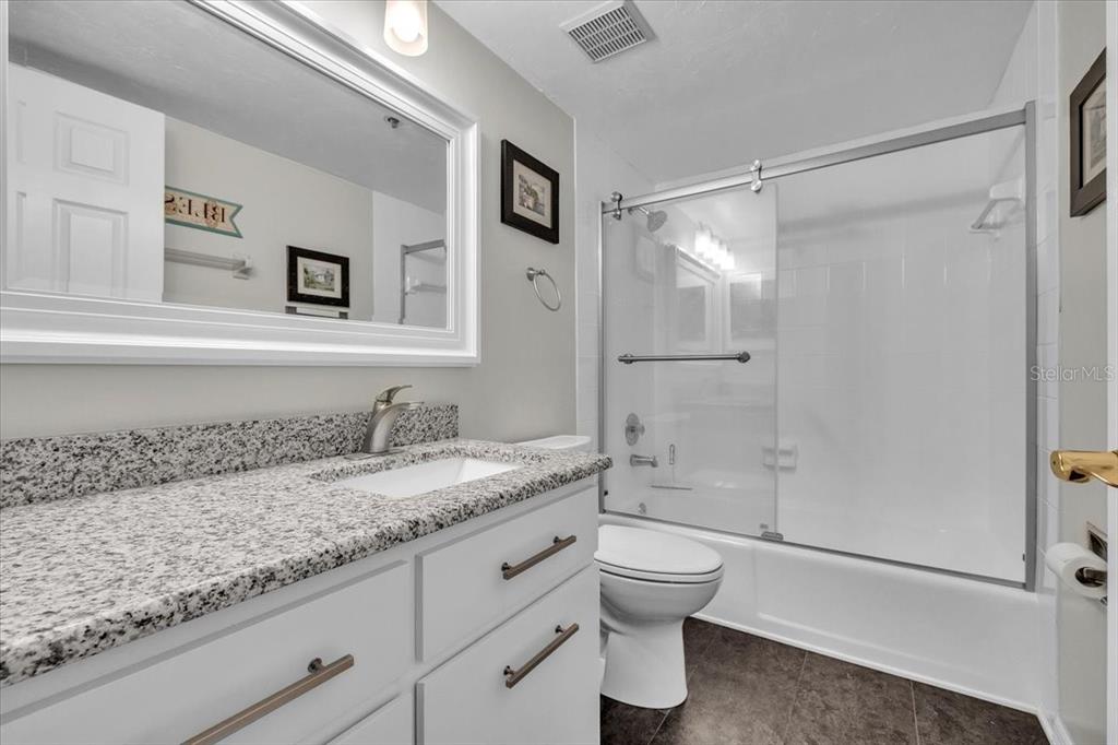 23465 Harbor View Road, Unit 624 Port Charlotte, FL 33980 - Photo 26 of 47 a bathroom with a granite countertop sink toilet and shower