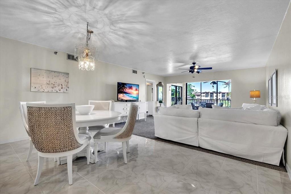 23465 Harbor View Road, Unit 624 Port Charlotte, FL 33980 - Photo 9 of 47 a living room with furniture and a chandelier